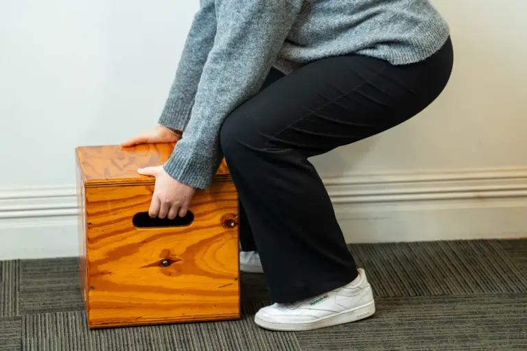 Candidate lifting a weighted box during a functional capacity assessment