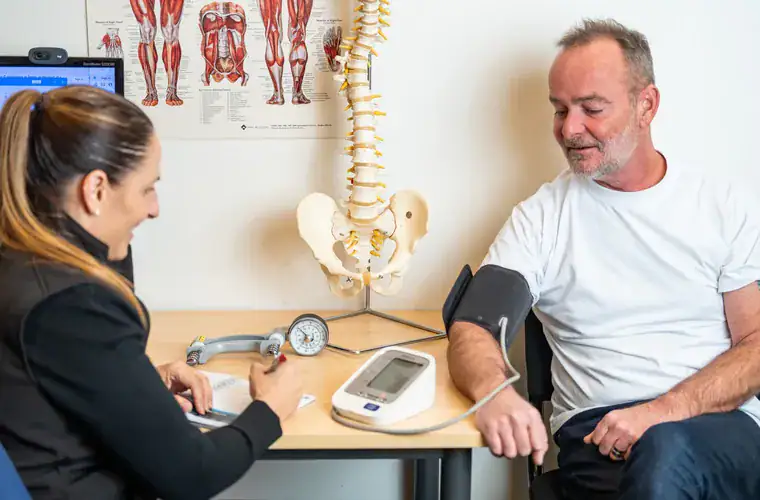 A Rehab Co clinician running an on-site health check for a worker