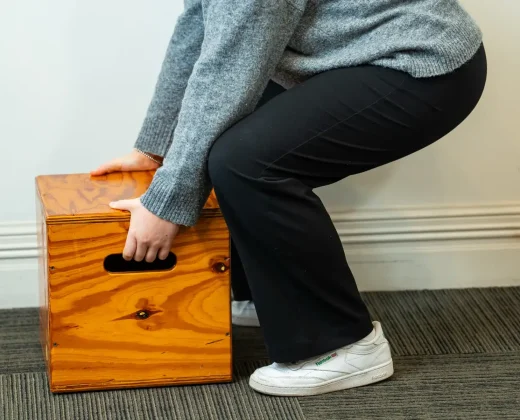 Candidate lifting a weighted box during a functional capacity assessment