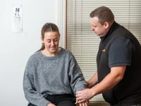 Rehab Co clinician examining a worker’s shoulder during early intervention