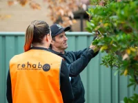 Rehab Co consultant observing a worker using a pole pruner on site